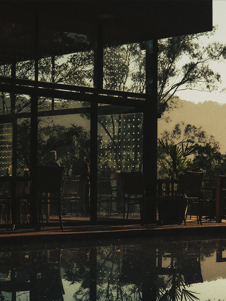 Espaço coberto da Reserva com piscina e vegetação ao entardecer