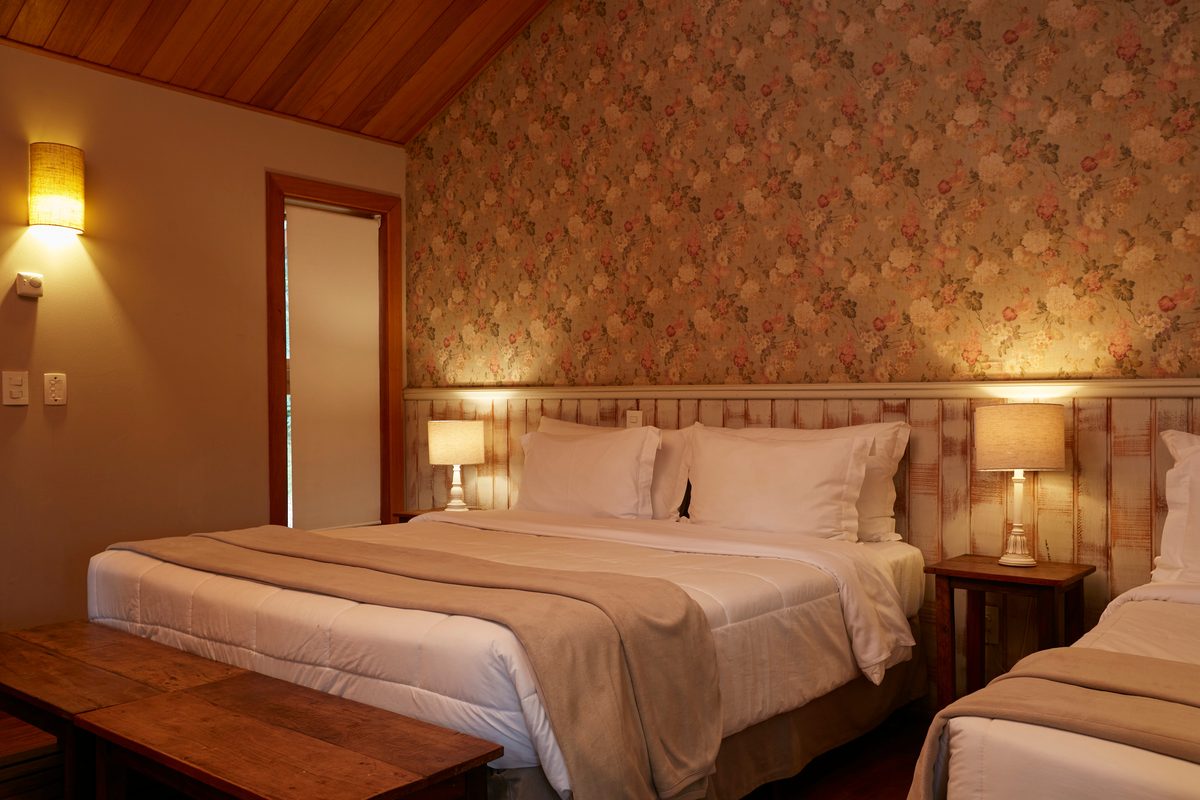 Quarto do Bangalô Premium com cama de casal, papel de parede floral e forro de madeira