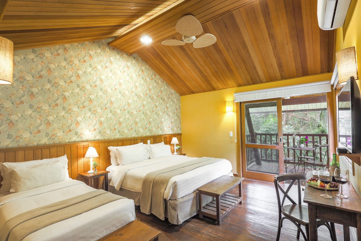 Quarto do Bangalô Premium com camas e porta para o terraço