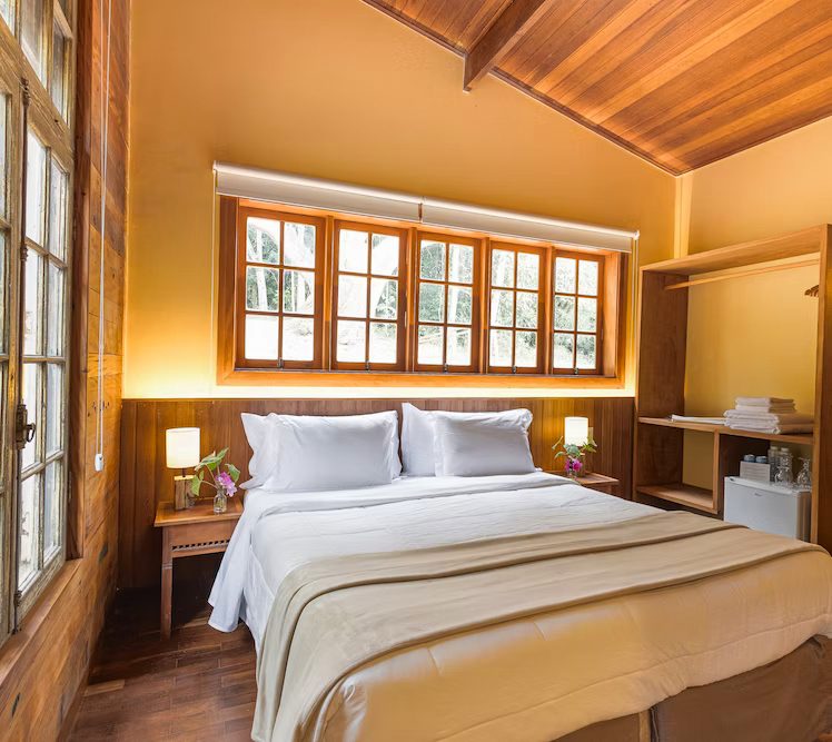 Quarto da Suíte Smart Casa de Pedra com janelas de madeira
