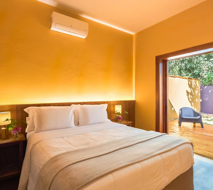 Quarto da Suíte Standard com cama de casal e porta para a varanda