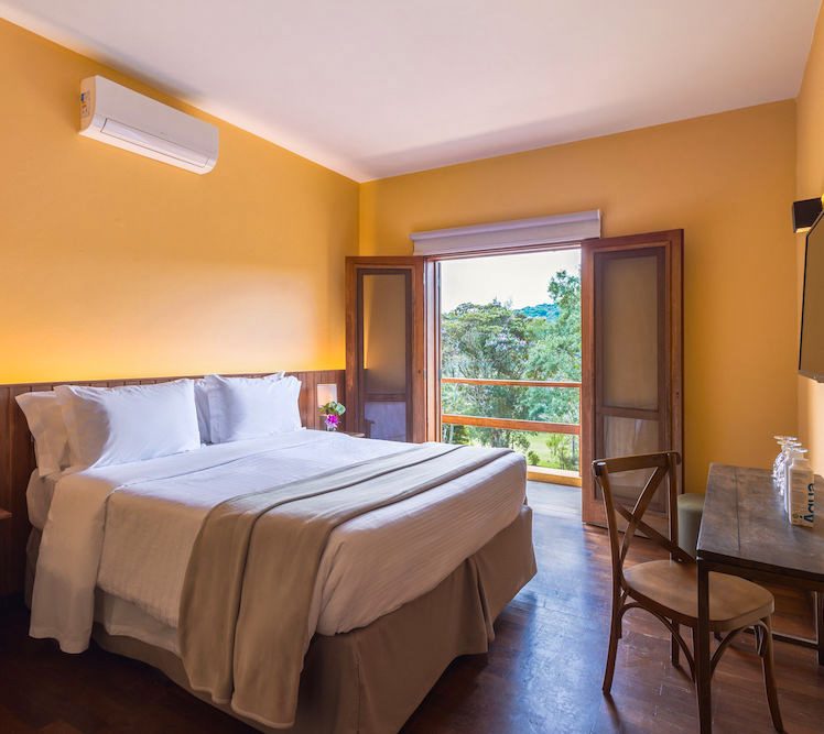 Quarto da Suíte Superior com janela aberta para a mata