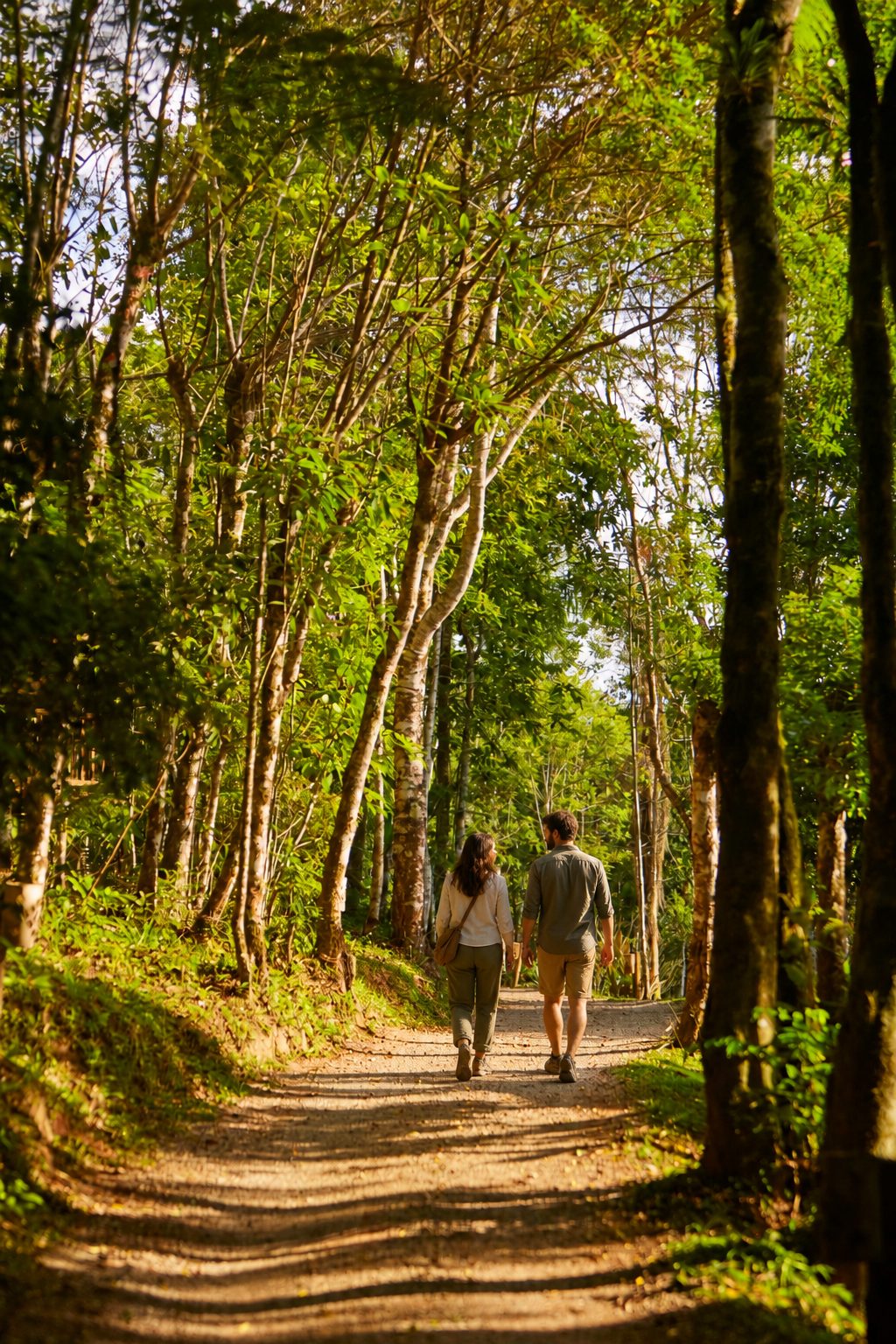 Casal caminhando por trilha entre as árvores da Reserva